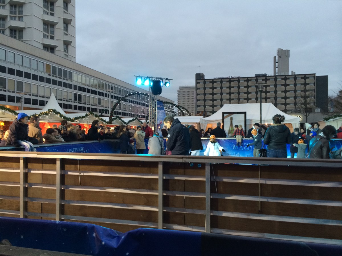 Les enfants heureux sur la patinoire du marché de Noël